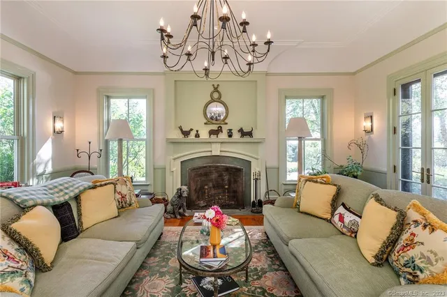 a living room with furniture a fireplace and a chandelier