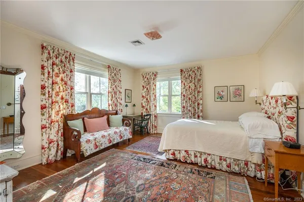 a spacious bedroom with a bed couch and a large window