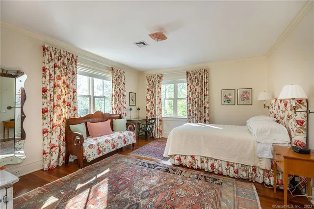 a spacious bedroom with a bed couch and a large window