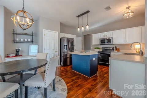 a kitchen with stainless steel appliances kitchen island granite countertop a sink refrigerator stove and microwave