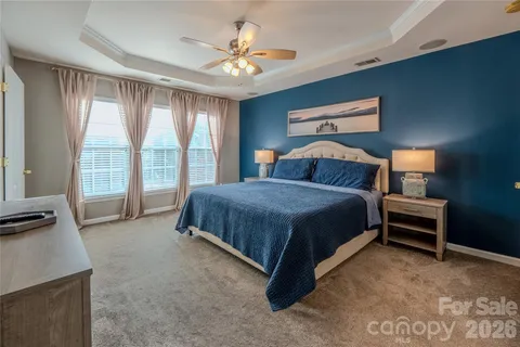 a spacious bedroom with a bed and a chandelier