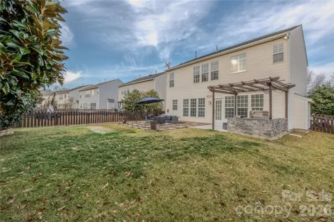 a view of a house with backyard and a tree