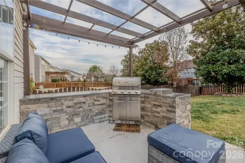 a roof deck with couches and wooden fence