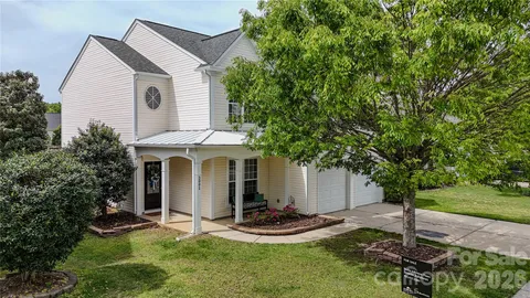 a view of a house with backyard and trees