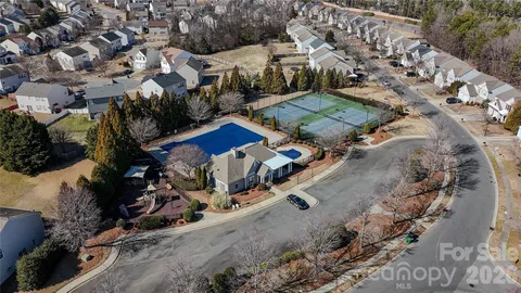 an aerial view of a house with a yard and parking