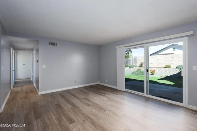 wooden floor fireplace and windows in an empty room