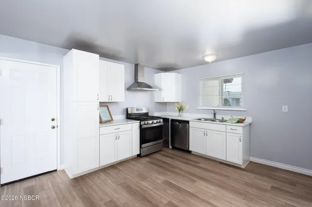 a kitchen with stainless steel appliances granite countertop a sink stove and cabinets