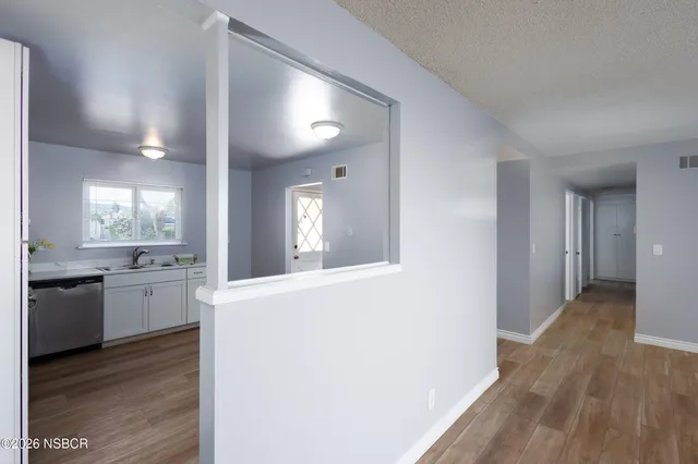 a view of an empty room with wooden floor