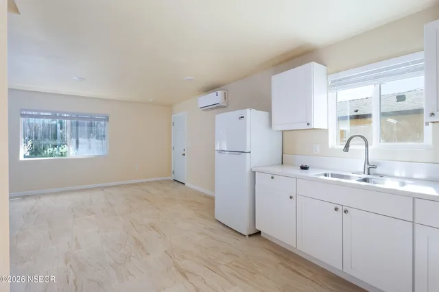 a kitchen with stainless steel appliances a refrigerator sink and white cabinets