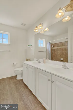 a spacious bathroom with a granite countertop sink mirror and toilet