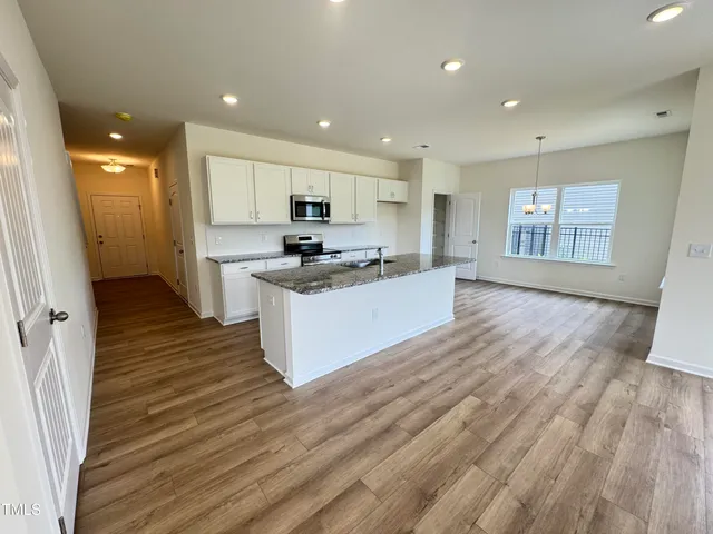 a living room with furniture kitchen and a potted plant