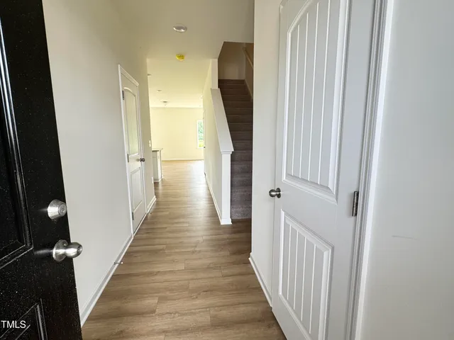 a view of a hallway with wooden floor and staircase