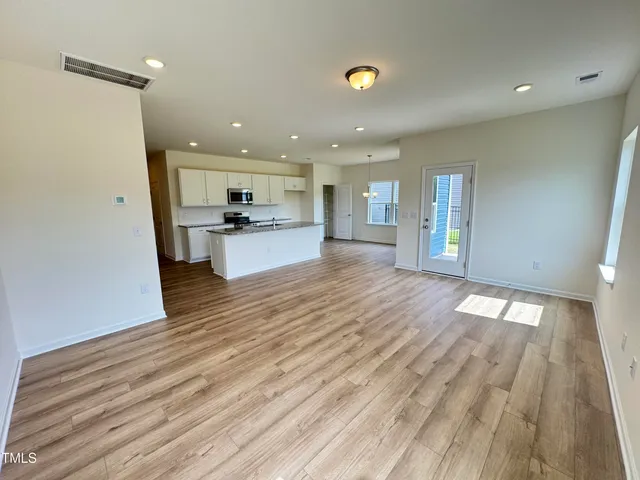 a view of a kitchen with wooden floor and a sink