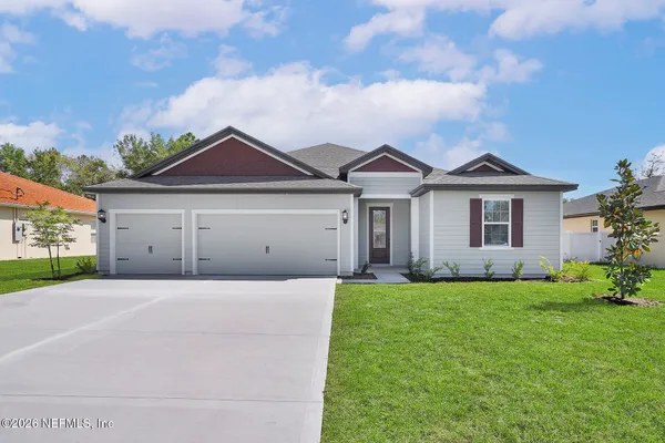 a front view of a house with a garden and yard
