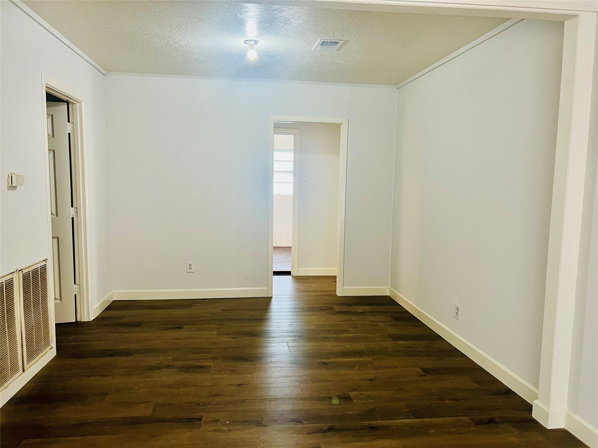 7328 Bauman Road Houston, TX 77022 - Photo 7 of 12 a view of an empty room with wooden floor and a window