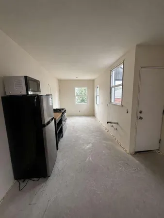 a view of a refrigerator in kitchen and a window