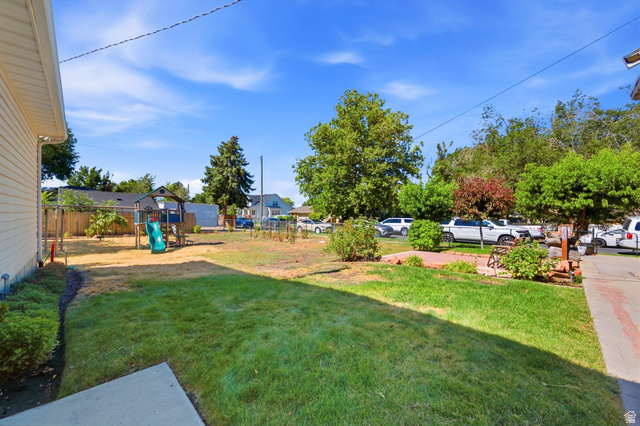 310 East 600 South Centerville, UT 84014 - Photo 25 of 41 Expansive backyard featuring a combination of established lawn and landscaping, a concrete patio area, and a wood fence