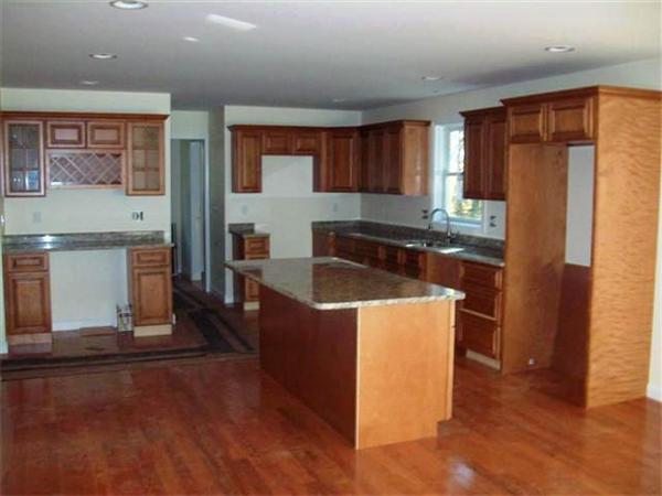 24 South Martin Road Amesbury, MA 01913 - Photo 4 of 8 a kitchen with stainless steel appliances granite countertop a refrigerator a sink dishwasher a stove with wooden cabinets and floor