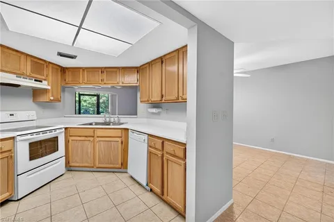 a white refrigerator freezer and a stove sitting inside of a kitchen