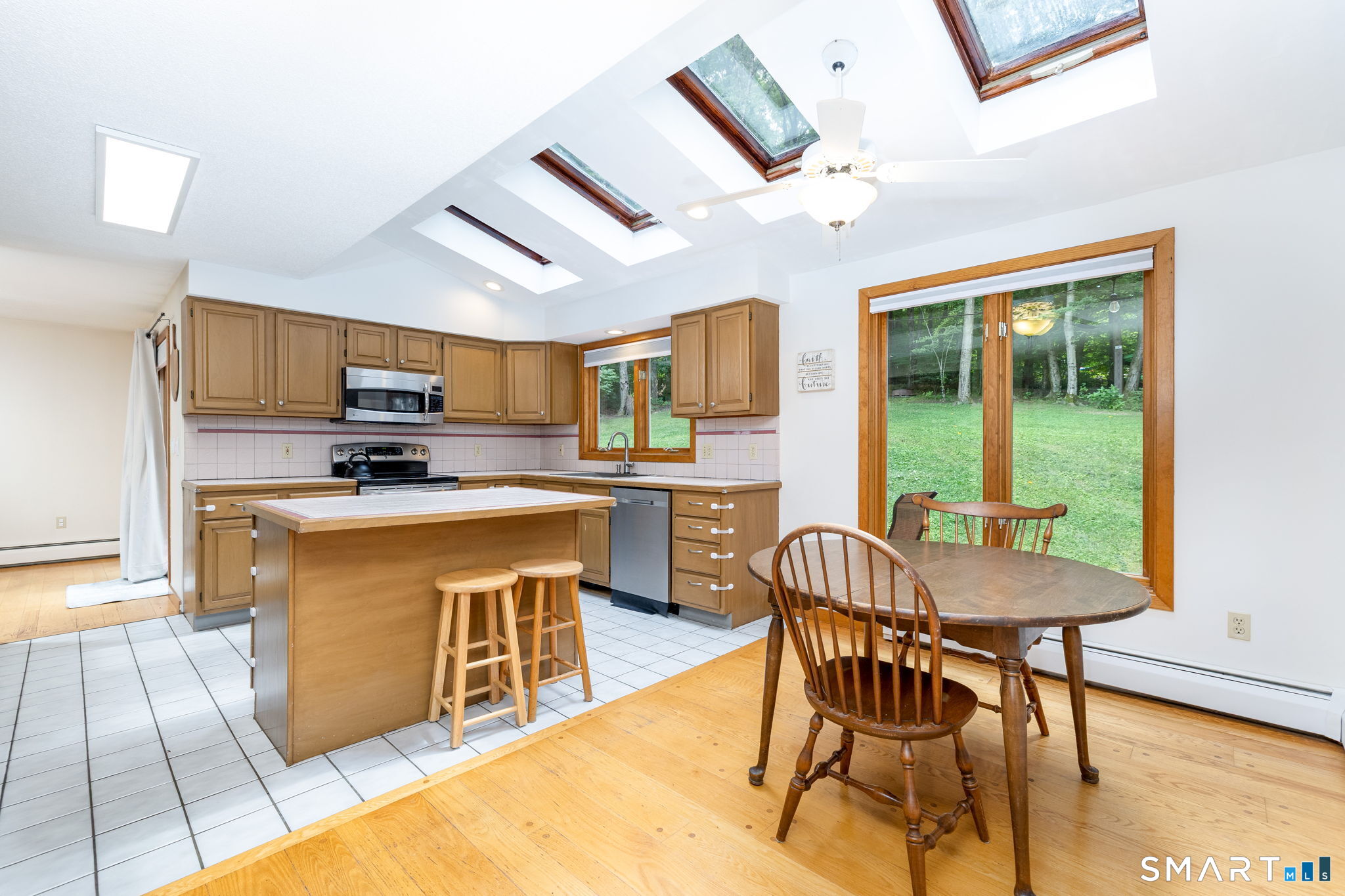 1386 Cedar Swamp Road Coventry, CT 06238 - Photo 14 of 39 Bright kitchen featuring skylights, a center island, plenty of cabinet space, and a comfortable kitchen table area for everyday meals and gathering.