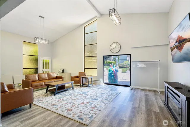 a living room with furniture a window and wooden floor