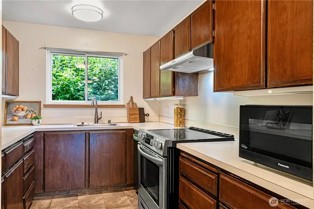 a kitchen with a sink stove and cabinets