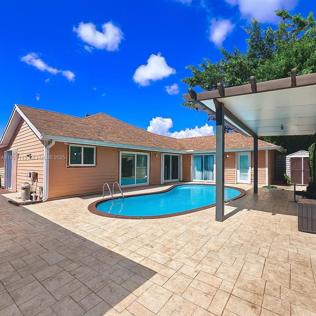 14145 Southwest 100th Terrace Miami, FL 33186 - Photo 13 of 15 a view of a house with a swimming pool