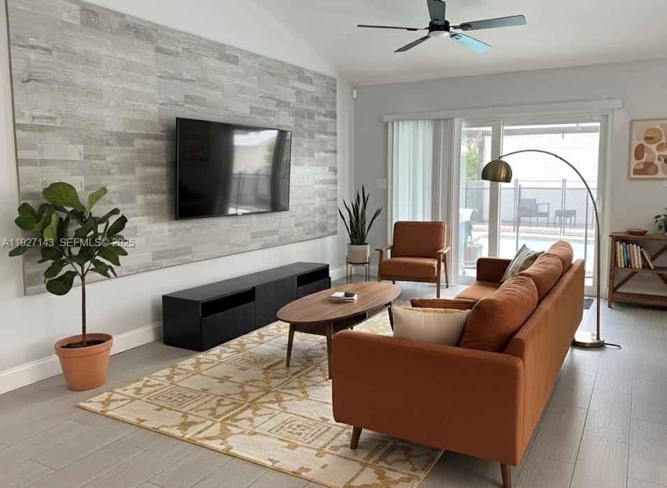 14145 Southwest 100th Terrace Miami, FL 33186 - Photo 2 of 15 a living room with furniture floor to ceiling window and a flat screen tv