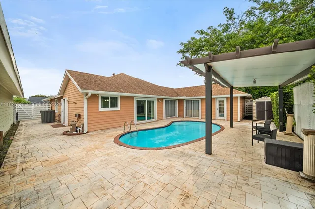 an aerial view of a house with a garden and lake view