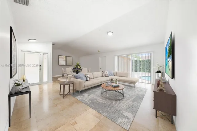 a living room with furniture kitchen area and a wooden floor