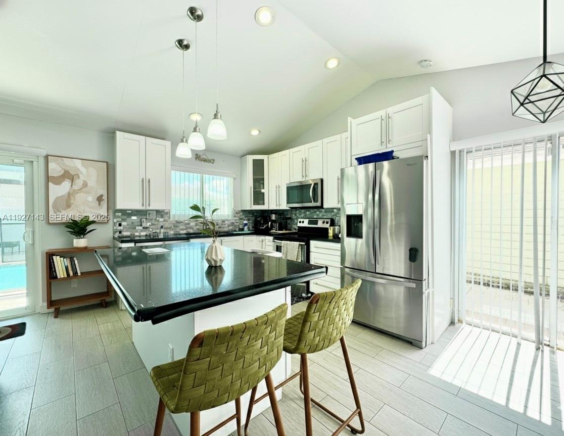 14145 Southwest 100th Terrace Miami, FL 33186 - Photo 6 of 15 a kitchen with stainless steel appliances granite countertop a refrigerator a sink dishwasher a stove and white cabinets with wooden floor