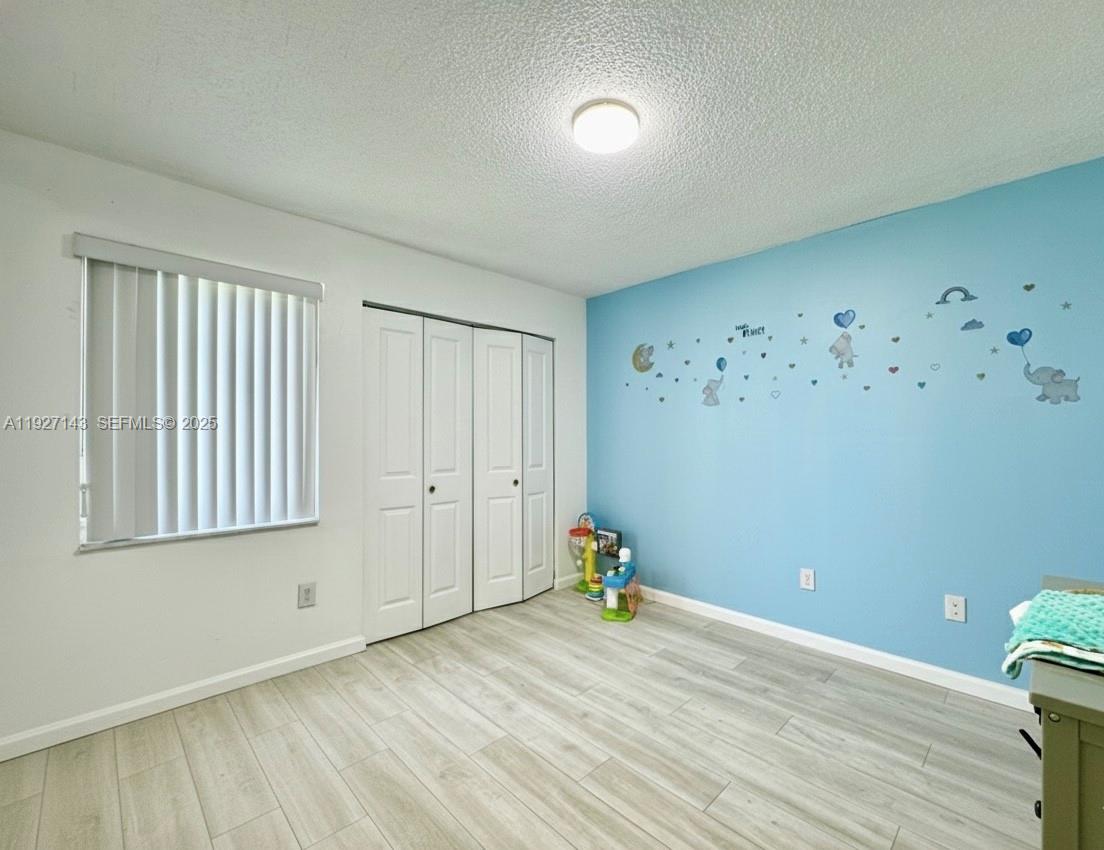 14145 Southwest 100th Terrace Miami, FL 33186 - Photo 8 of 15 a view of a room with wooden floor and white walls