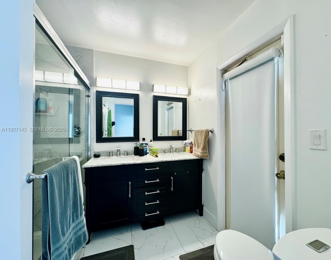 14145 Southwest 100th Terrace Miami, FL 33186 - Photo 9 of 15 a bathroom with a double vanity sink mirror and toilet
