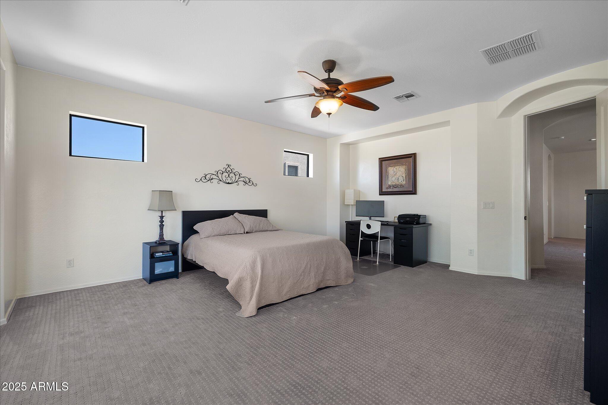 8536 East Inca Street Mesa, AZ 85207 - Photo 20 of 44 a spacious bedroom with a bed and a chandelier