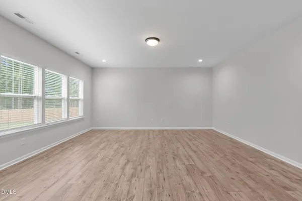 an empty room with wooden floor and entryway
