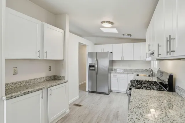 a kitchen with stainless steel appliances granite countertop a stove a refrigerator and a granite counter tops