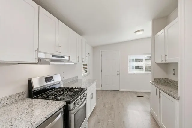 a kitchen with granite countertop a stove and a sink