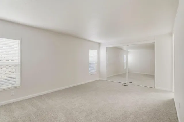 an empty room with windows and closet