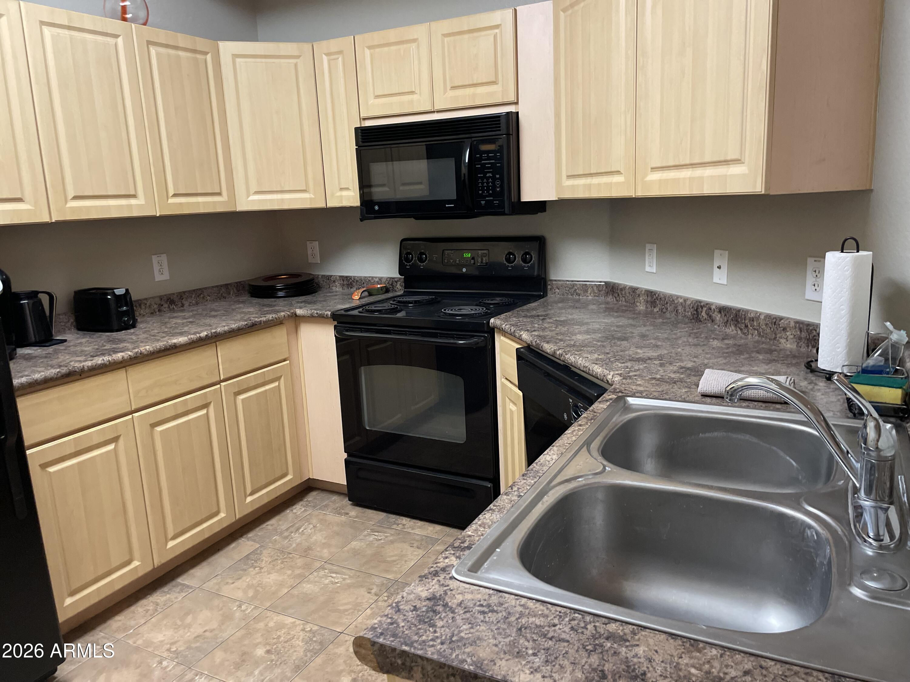 5303 North 7th Street, Unit 113 Phoenix, AZ 85014 - Photo 11 of 21 a kitchen with granite countertop a sink and a stove top oven