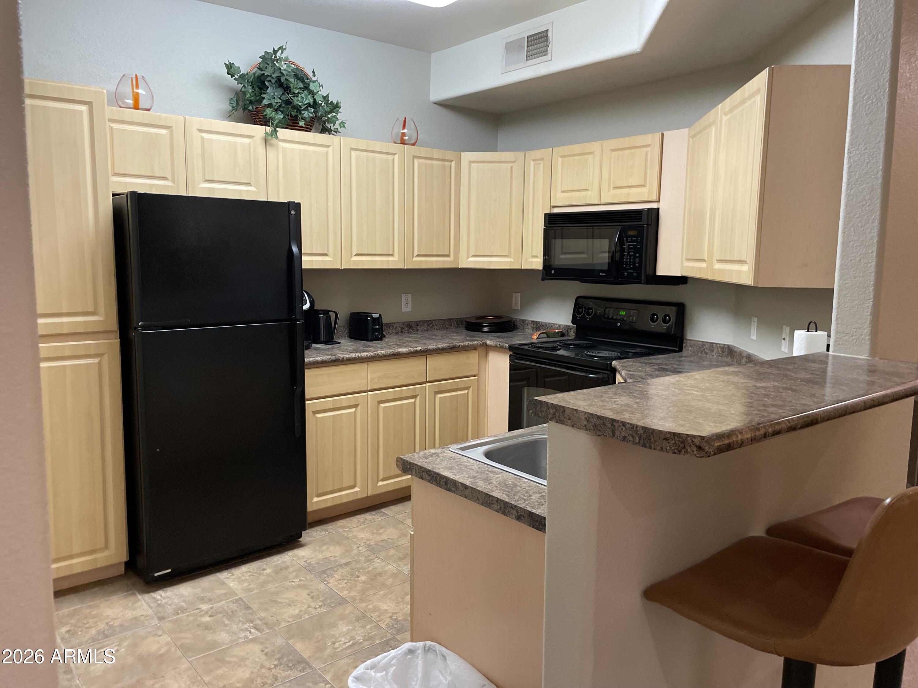 5303 North 7th Street, Unit 113 Phoenix, AZ 85014 - Photo 10 of 21 a kitchen with granite countertop a refrigerator stove a sink and dishwasher with kitchen countertops