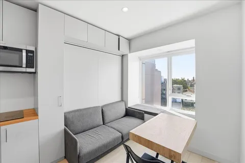 a kitchen with a refrigerator and white cabinets
