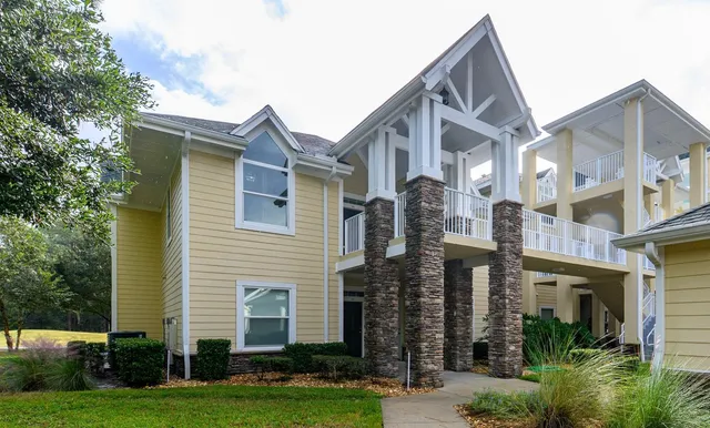 a front view of a house with a yard and trees