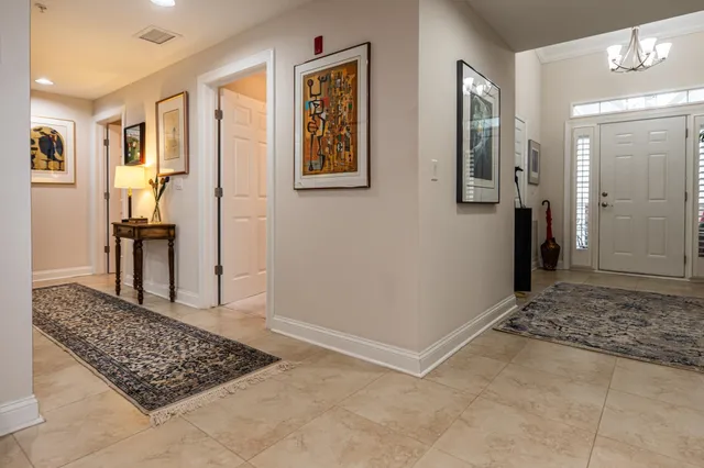 a dining room with furniture a rug a potted plant and a chandelier