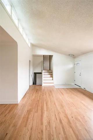 a view of empty room with wooden floor and fireplace