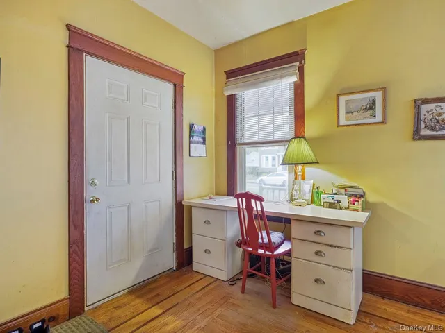 a view of a workspace with furniture and a window