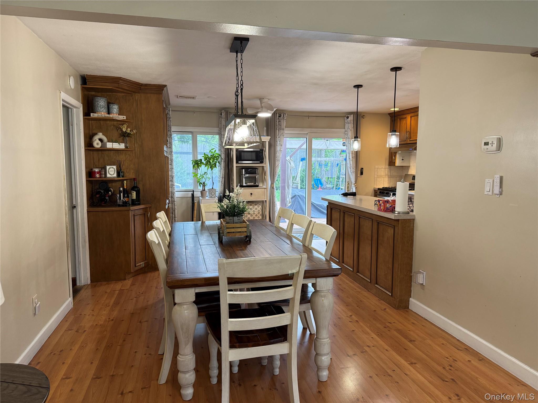 161 Hawkins Road Centereach, NY 11720 - Photo 7 of 16 a view of a dining room and livingroom with furniture wooden floor a chandelier