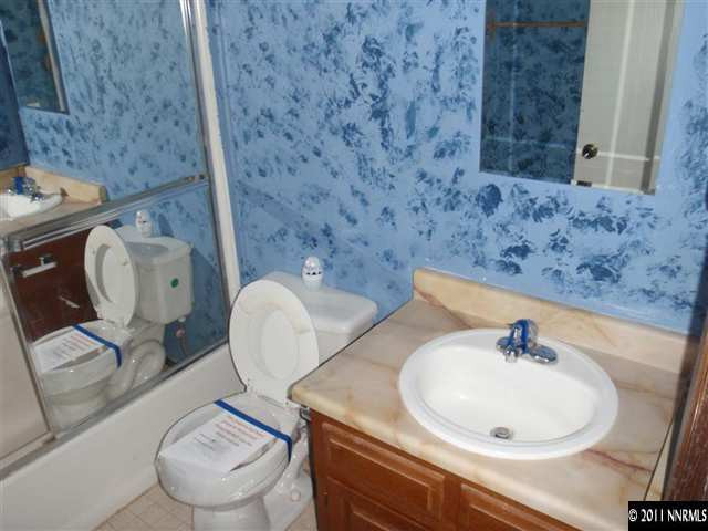 235 Ring Road Dayton, NV 89403 - Photo 5 of 13 a bathroom with a toilet a sink and mirror