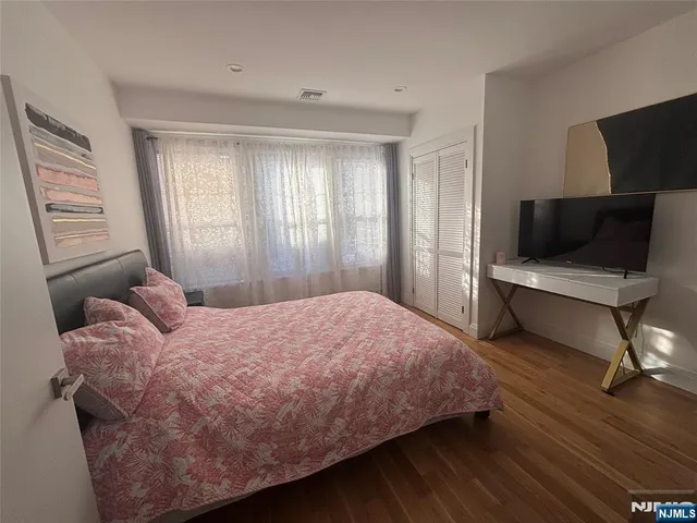 a bedroom with a bed tv and a window