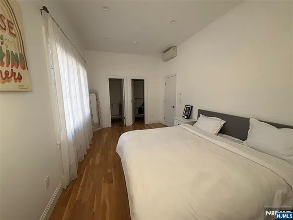 a spacious bedroom with a bed and wooden floor