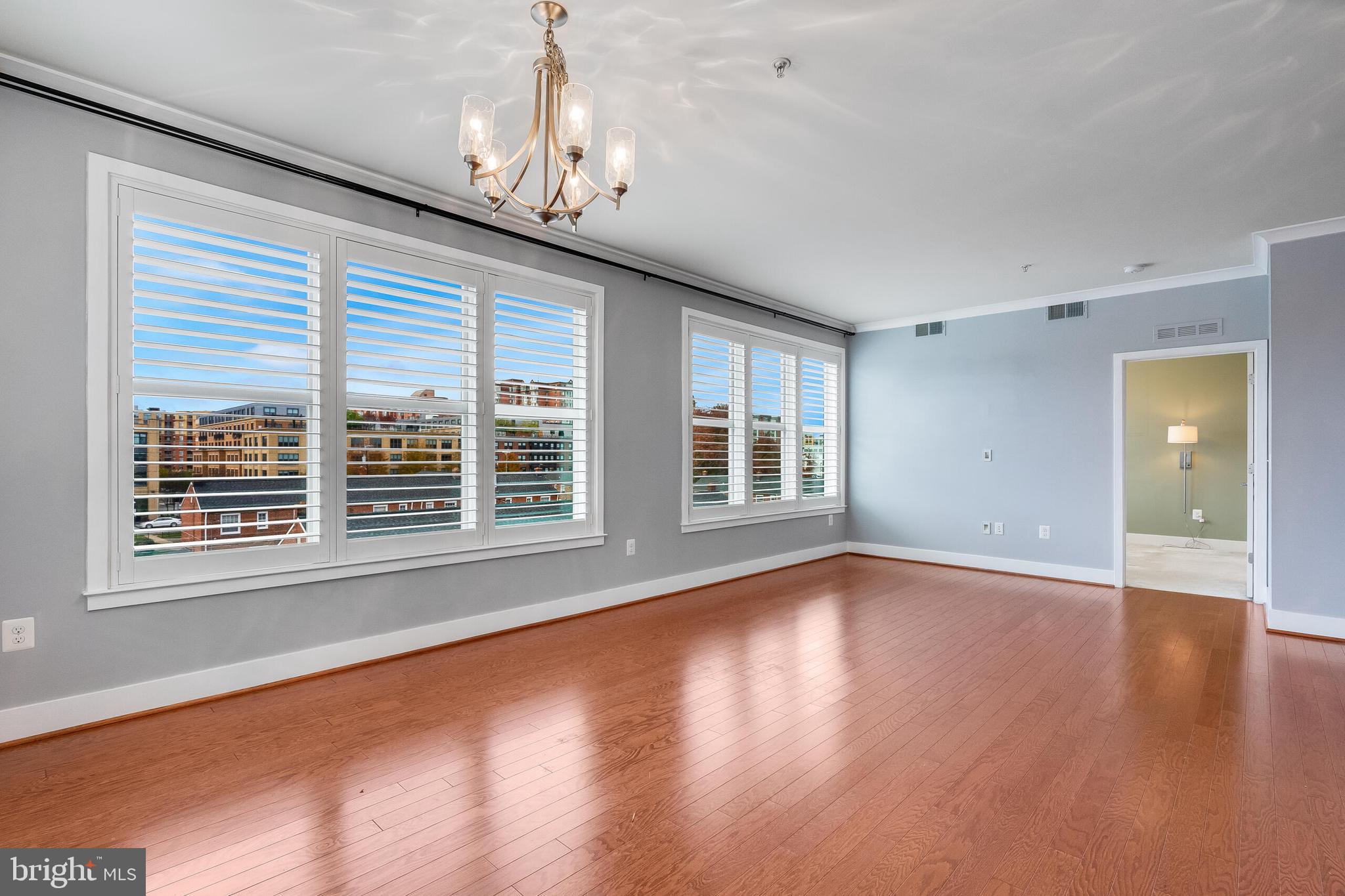 815 North Patrick Street, Unit 402 Alexandria, VA 22314 - Photo 12 of 23 a view of an empty room with wooden floor and a window